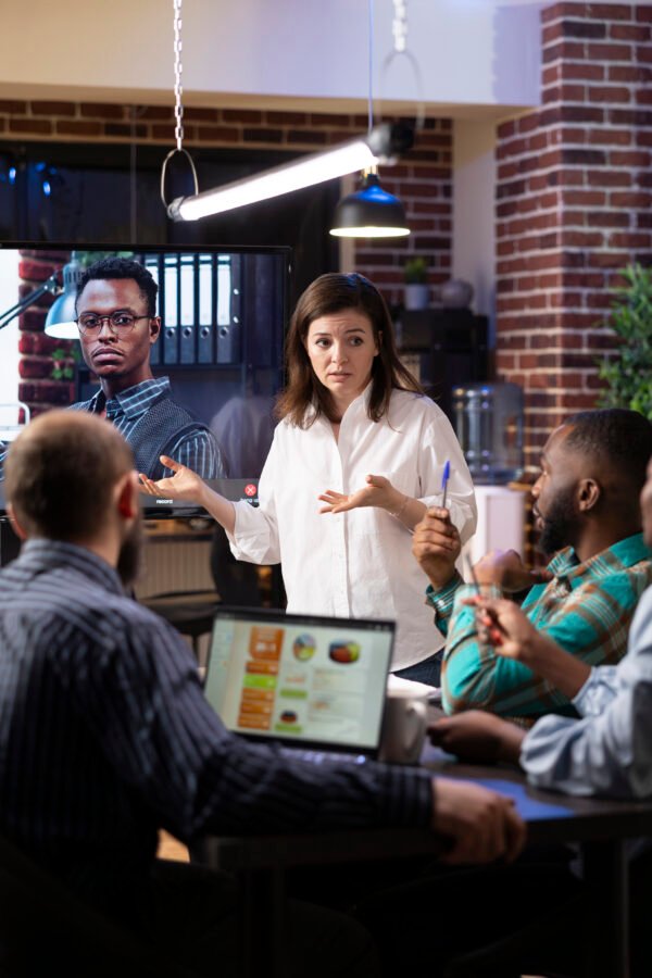 Coworkers engaged in virtual meeting in office Aliados de Marca