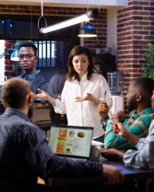 Coworkers engaged in virtual meeting in office Aliados de Marca
